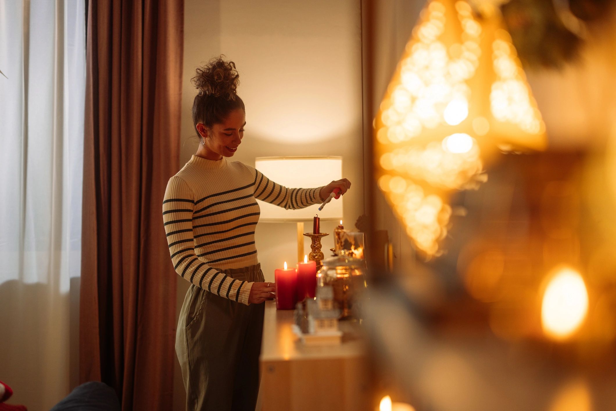 Detalle de una vela encendida en un ambiente acogedor